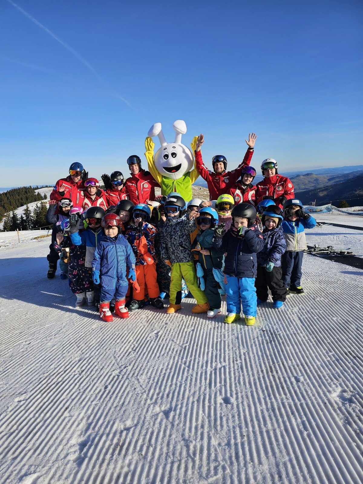 Un groupe d’enfants, leurs moniteurs et Snowli